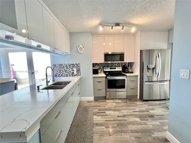 15333 SW 40th Ter, Miami, FL 33185 - kitchen featuring stainless steel appliances, a sink, modern cabinets, decorative backsplash, and a textured ceiling