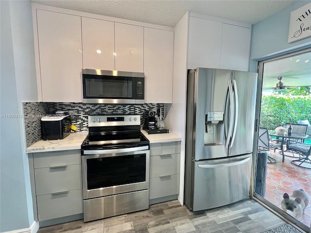 15333 SW 40th Ter, Miami, FL 33185 - kitchen with appliances with stainless steel finishes, light wood-style flooring, decorative backsplash, modern cabinets, and a textured ceiling