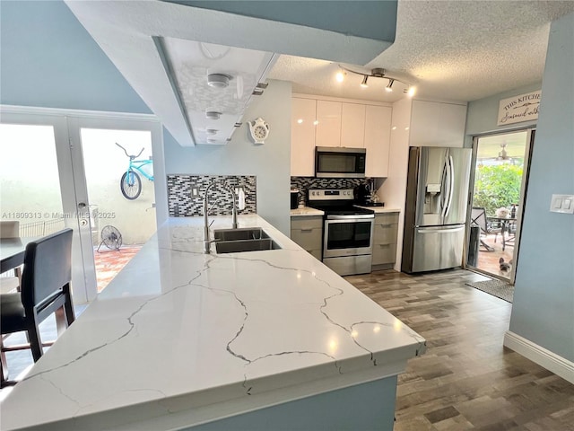 15333 SW 40th Ter, Miami, FL 33185 - kitchen featuring stainless steel appliances, a sink, backsplash, a textured ceiling, and wood finished floors