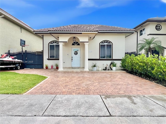 15333 SW 40th Ter, Miami, FL 33185 - mediterranean / spanish-style house featuring a tiled roof, stucco siding, and a gate