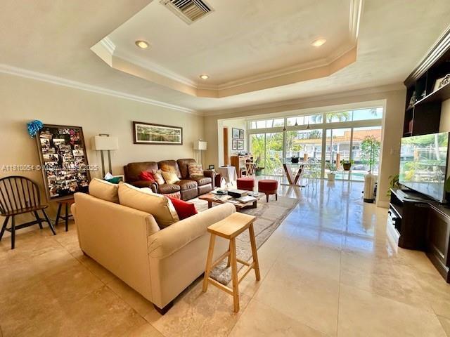 1945 N Hibiscus Dr, North Miami, FL 33181 - living area with a raised ceiling, ornamental molding, light tile patterned flooring, and recessed lighting