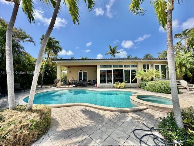 1945 N Hibiscus Dr, North Miami, FL 33181 - view of swimming pool featuring a patio area, french doors, and a pool with connected hot tub
