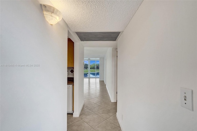 9450 Poinciana Pl Unit 212, Davie, FL 33324 - hallway with light tile patterned floors, a textured ceiling, and baseboards