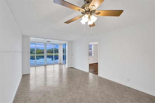 9450 Poinciana Pl Unit 212, Davie, FL 33324 - unfurnished room featuring expansive windows, light tile patterned floors, a ceiling fan, baseboards, and a water view