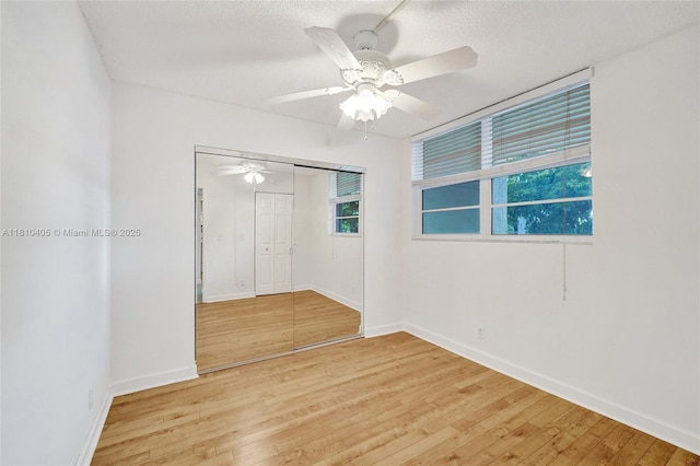9450 Poinciana Pl Unit 212, Davie, FL 33324 - unfurnished bedroom featuring light wood-style floors, a closet, baseboards, ceiling fan, and a textured ceiling