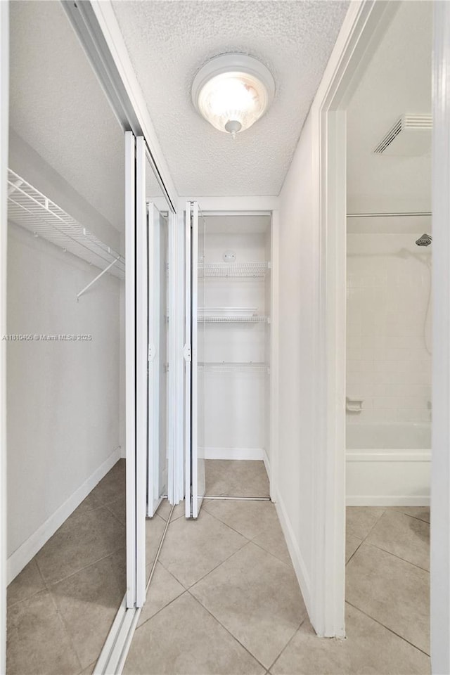9450 Poinciana Pl Unit 212, Davie, FL 33324 - corridor with a textured ceiling, light tile patterned floors, and baseboards