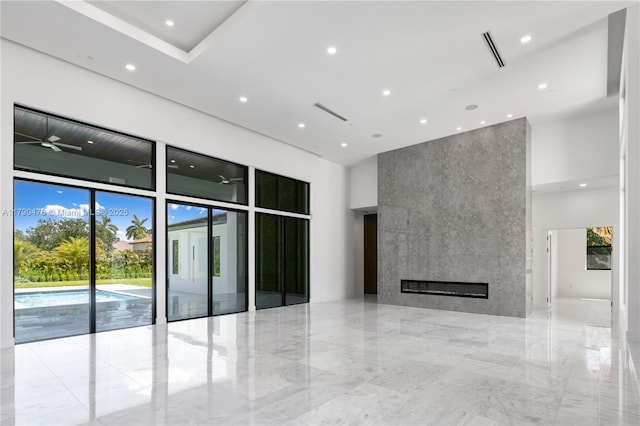 12331 SW 2nd St, Plantation, FL 33325 - unfurnished living room featuring a high ceiling, elevator, light marble finish flooring, recessed lighting, and a large fireplace