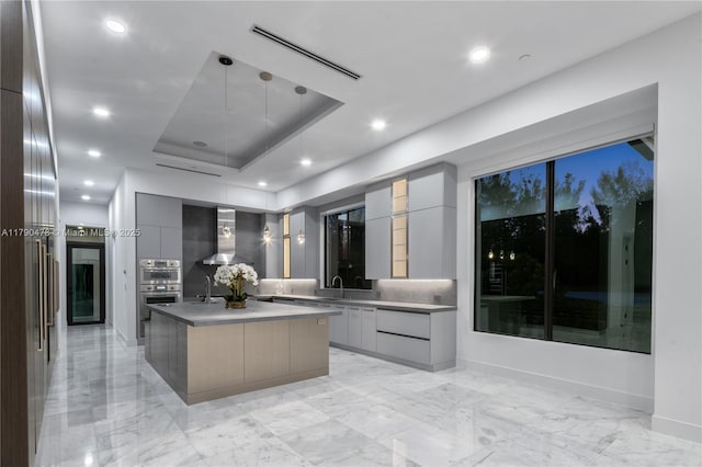 12331 SW 2nd St, Plantation, FL 33325 - kitchen with modern cabinets, wall chimney range hood, double oven, light marble finish flooring, and gray cabinetry