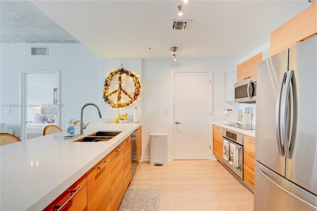 3301 NE 1st Ave Unit H2304, Miami, FL 33137 - kitchen with stainless steel appliances, light wood-style flooring, light countertops, rail lighting, and modern cabinets