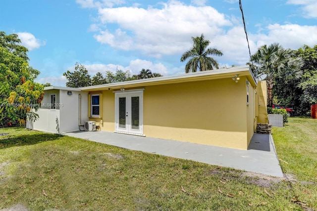 5156 Hartwick Ln, West Palm Beach, FL 33415 - rear view of property featuring french doors, stucco siding, a yard, and a patio