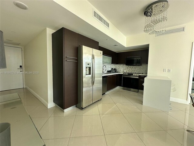 950 Brickell Bay Dr Unit 2607, Miami, FL 33131 - kitchen with appliances with stainless steel finishes, decorative backsplash, light countertops, baseboards, and light tile patterned flooring