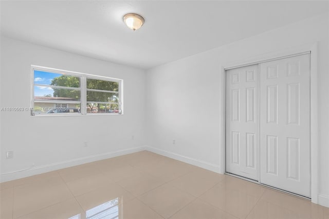 3202 SW 3rd St, Miami, FL 33135 - unfurnished bedroom featuring a closet, baseboards, and tile patterned flooring