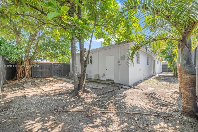 3202 SW 3rd St, Miami, FL 33135 - rear view of house featuring a fenced backyard, a gate, stucco siding, and a patio