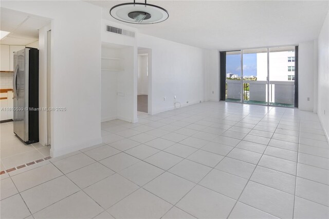 800 W Ave Unit 920, Miami Beach, FL 33139 - spare room with floor to ceiling windows, light tile patterned floors, and baseboards