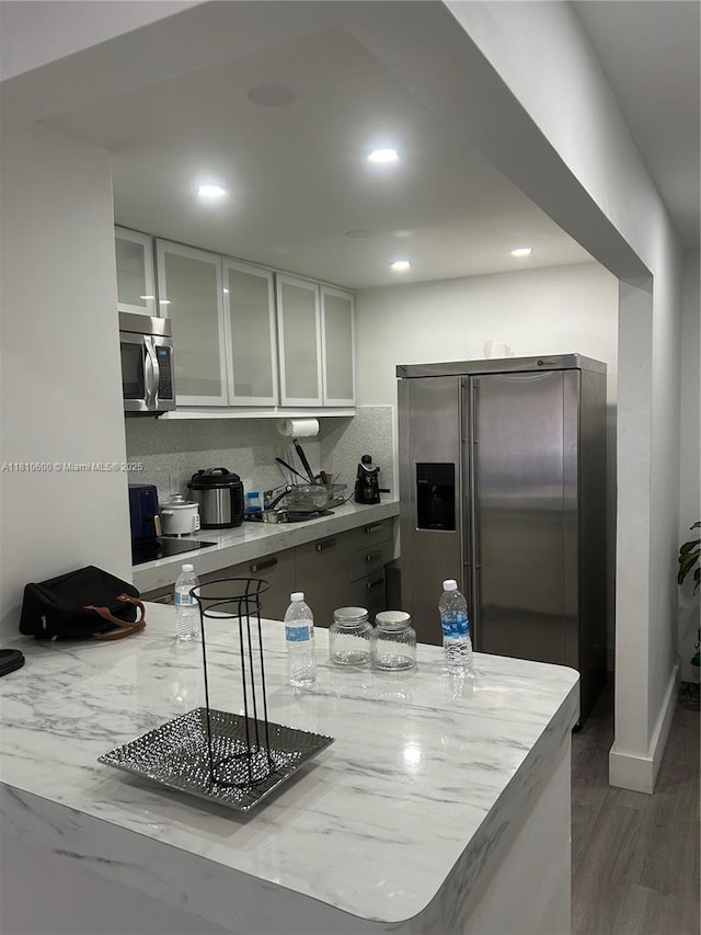 6095 W 19th Ave Unit 209, Hialeah, FL 33012 - kitchen with stainless steel appliances, glass insert cabinets, white cabinetry, light stone counters, and recessed lighting