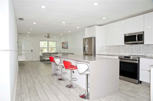 1328 NW 93rd Ter, Coral Springs, FL 33071 - kitchen with appliances with stainless steel finishes, modern cabinets, light wood-style flooring, white cabinetry, and recessed lighting