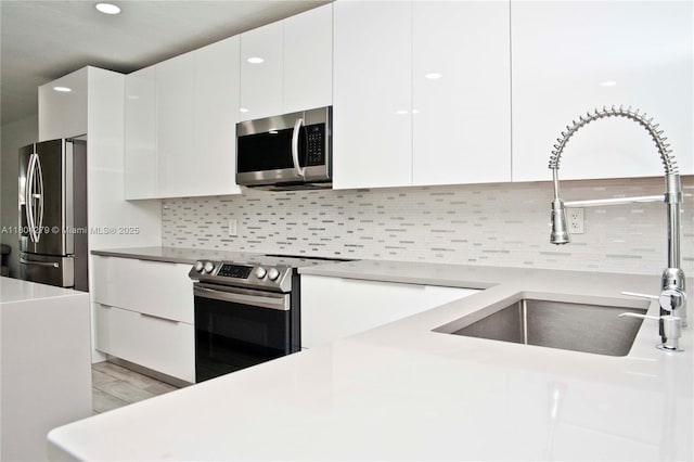 1328 NW 93rd Ter, Coral Springs, FL 33071 - kitchen with appliances with stainless steel finishes, a sink, modern cabinets, white cabinetry, and backsplash