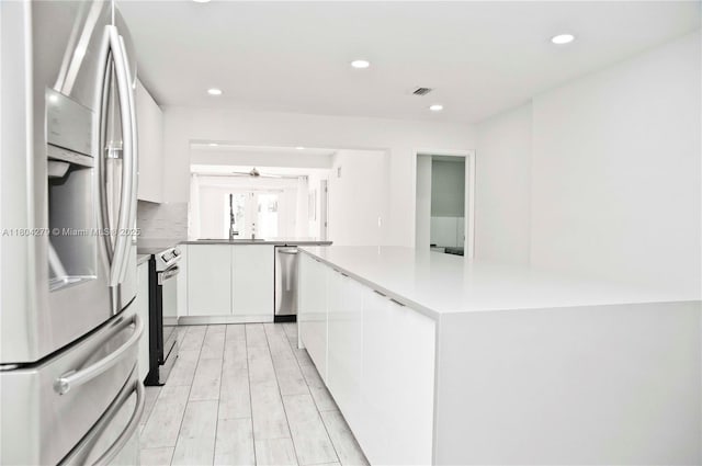 1328 NW 93rd Ter, Coral Springs, FL 33071 - kitchen with appliances with stainless steel finishes, white cabinetry, light countertops, recessed lighting, and modern cabinets