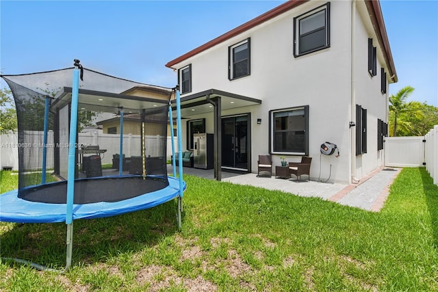 3534 W 106th St, Hialeah, FL 33018 - back of property featuring a trampoline, stucco siding, and a patio area