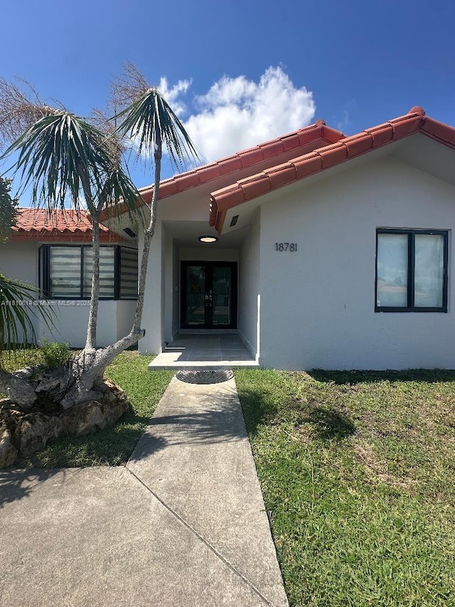 18781 SW 294th Ter, Homestead, FL 33030 - view of exterior entry featuring french doors, stucco siding, and a tiled roof