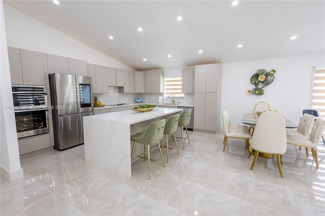 18781 SW 294th Ter, Homestead, FL 33030 - kitchen with appliances with stainless steel finishes, gray cabinetry, a center island, a breakfast bar area, and light countertops