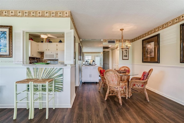 284 Prescott N Unit 284, Deerfield Beach, FL 33442 - dining room featuring wood finished floors, a textured ceiling, wainscoting, baseboards, and a chandelier