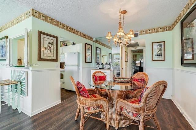 284 Prescott N Unit 284, Deerfield Beach, FL 33442 - dining area featuring a chandelier, a textured ceiling, wainscoting, dark wood-type flooring, and baseboards