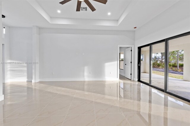 452 Mercedes Ct, Lehigh Acres, FL 33972 - unfurnished room featuring light marble finish floors, ceiling fan, a raised ceiling, and baseboards