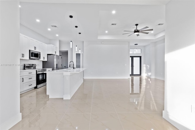 452 Mercedes Ct, Lehigh Acres, FL 33972 - kitchen featuring appliances with stainless steel finishes, open floor plan, light marble finish floors, a raised ceiling, and baseboards