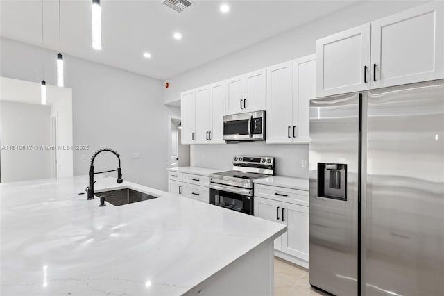 452 Mercedes Ct, Lehigh Acres, FL 33972 - kitchen featuring stainless steel appliances, a sink, white cabinets, pendant lighting, and recessed lighting
