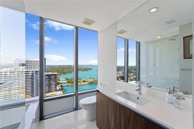 3131 NE 7th Ave Unit 3106, Miami, FL 33137 - bathroom featuring a water view, toilet, a wall of windows, vanity, and tile patterned floors