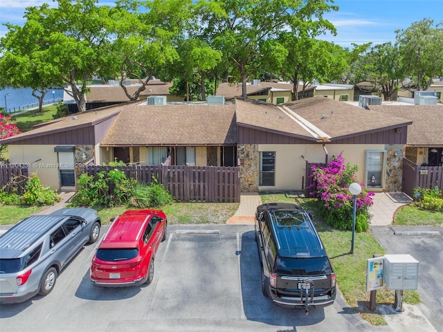 306 Cambridge Rd Unit 2-36, Hollywood, FL 33024 - view of front of house featuring a shingled roof, uncovered parking, and stone siding