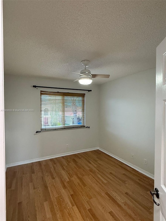 5552 NW 125th Ter, Coral Springs, FL 33076 - empty room with wood finished floors, a ceiling fan, a textured ceiling, and baseboards