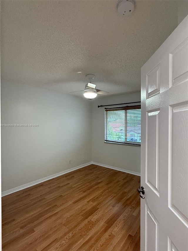 5552 NW 125th Ter, Coral Springs, FL 33076 - empty room featuring light wood-style floors, a textured ceiling, and baseboards