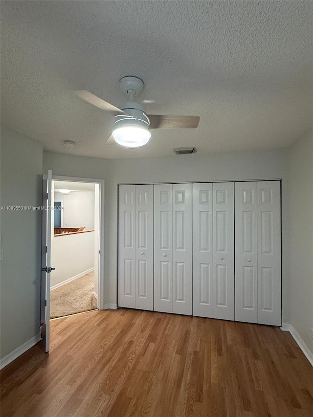 5552 NW 125th Ter, Coral Springs, FL 33076 - unfurnished bedroom with a textured ceiling, wood finished floors, baseboards, a ceiling fan, and a closet