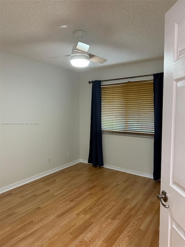 5552 NW 125th Ter, Coral Springs, FL 33076 - unfurnished room with a textured ceiling, light wood-style floors, a ceiling fan, and baseboards