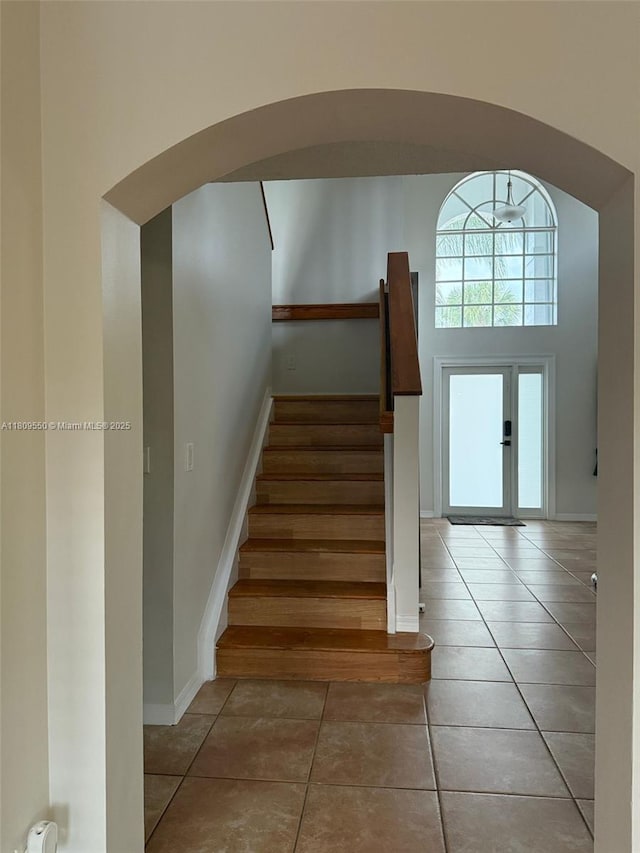 5552 NW 125th Ter, Coral Springs, FL 33076 - stairs with tile patterned floors, arched walkways, and baseboards