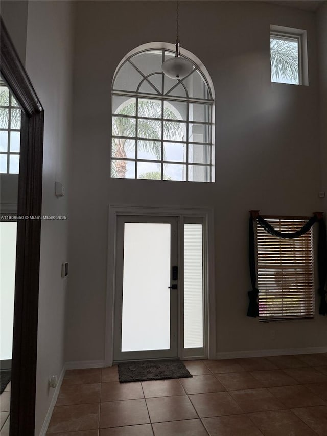 5552 NW 125th Ter, Coral Springs, FL 33076 - entryway featuring healthy amount of natural light, tile patterned flooring, a towering ceiling, and baseboards