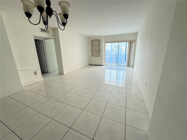 400 Kings Point Dr Unit 318, Sunny Isles Beach, FL 33160 - spare room with light tile patterned floors, built in features, and a chandelier