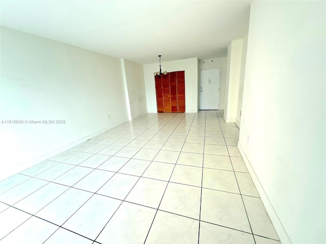 400 Kings Point Dr Unit 318, Sunny Isles Beach, FL 33160 - unfurnished room featuring light tile patterned flooring, a chandelier, and baseboards