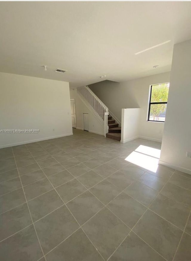 28729 SW 132nd Pl Unit 28729, Homestead, FL 33033 - unfurnished living room featuring stairway, light tile patterned floors, and baseboards