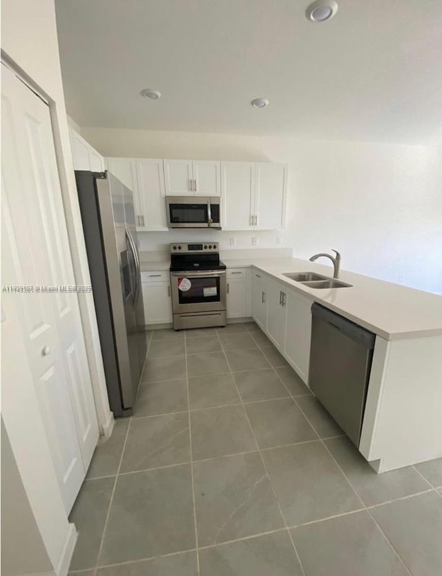 28729 SW 132nd Pl Unit 28729, Homestead, FL 33033 - kitchen featuring appliances with stainless steel finishes, a sink, light tile patterned floors, a peninsula, and light countertops
