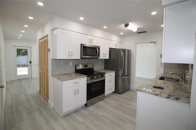7204 NW 76th Dr, Tamarac, FL 33321 - kitchen featuring appliances with stainless steel finishes, a sink, light wood-style floors, tasteful backsplash, and recessed lighting