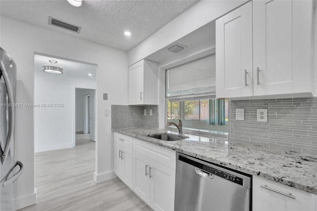 7204 NW 76th Dr, Tamarac, FL 33321 - kitchen with dishwasher, light stone counters, backsplash, white cabinets, and a textured ceiling