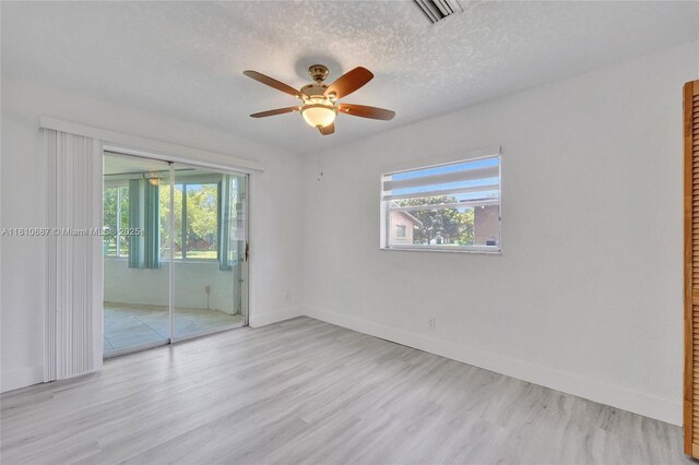 7204 NW 76th Dr, Tamarac, FL 33321 - unfurnished bedroom featuring wood finished floors, a textured ceiling, a ceiling fan, a closet, and access to exterior