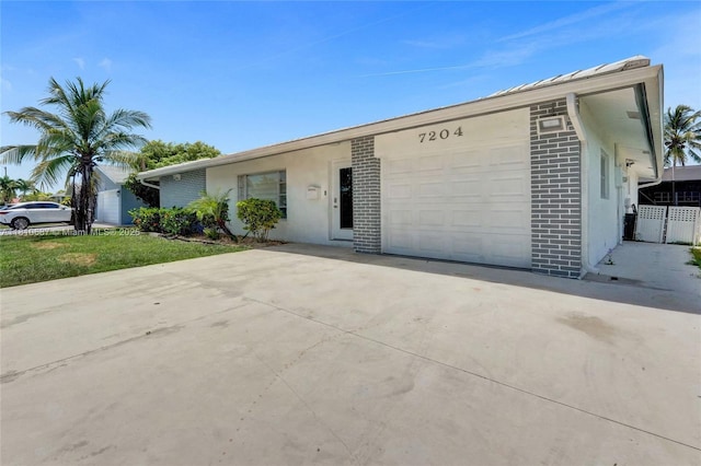 7204 NW 76th Dr, Tamarac, FL 33321 - ranch-style house with concrete driveway, a garage, brick siding, and stucco siding