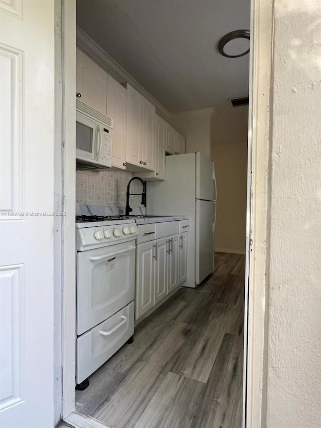 915 N 19th Ave, Hollywood, FL 33020 - kitchen featuring white appliances, crown molding, light wood-style flooring, a sink, and tasteful backsplash