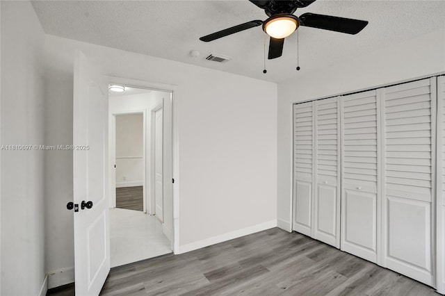 7325 Flores Way, Margate, FL 33063 - unfurnished bedroom featuring a textured ceiling, wood finished floors, a closet, baseboards, and ceiling fan