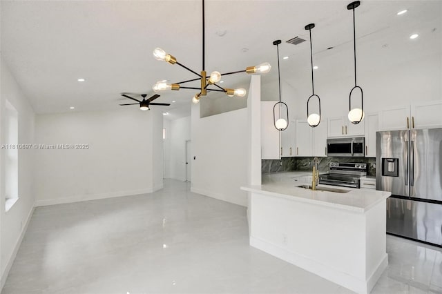 7325 Flores Way, Margate, FL 33063 - kitchen with stainless steel appliances, a sink, baseboards, a chandelier, and a high ceiling