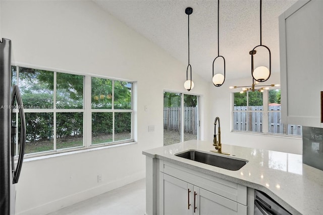 7325 Flores Way, Margate, FL 33063 - kitchen with a sink, freestanding refrigerator, light stone countertops, dishwasher, and decorative light fixtures